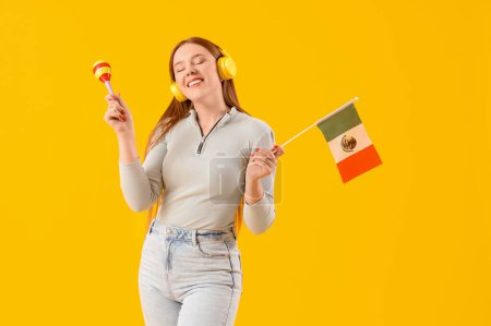 Junge Frau mit Kopfhörern mit mexikanischer Flagge und Maraca auf gelbem Hintergrund