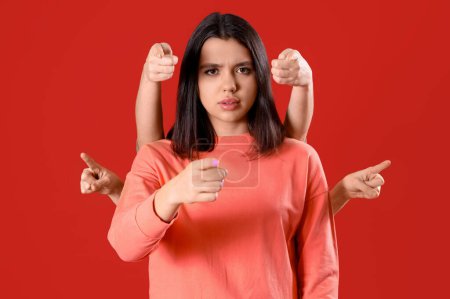 Photo for Young woman and people pointing at viewer on red background. Accusation concept - Royalty Free Image