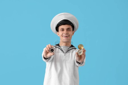 Photo for Young sailor with compasses on blue background - Royalty Free Image
