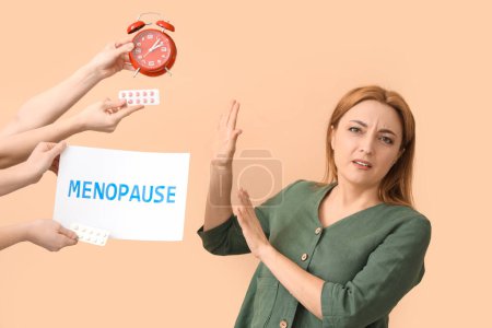 Mature woman rejecting pills and alarm clock on beige background. Menopause concept