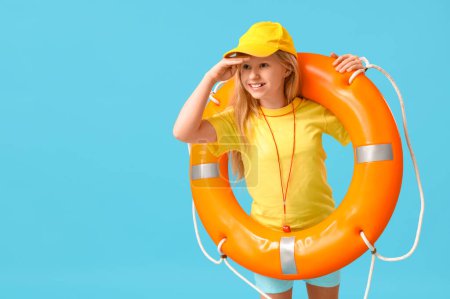 Photo for Happy little girl lifeguard with ring buoy on blue background - Royalty Free Image