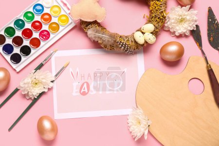 Composición con tarjeta de felicitación, materiales para pintores y decoración de Pascua sobre fondo rosa