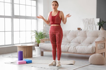 Mujer madura deportista conmocionada midiendo su peso en casa. Concepto de menopausia