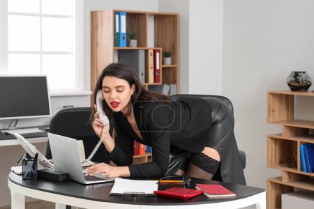 Attractive secretary talking by telephone in office
