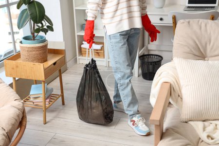 Frau mit Müllsack im Wohnzimmer