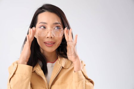 Photo for Young Asian woman in eyeglasses on white background, closeup - Royalty Free Image