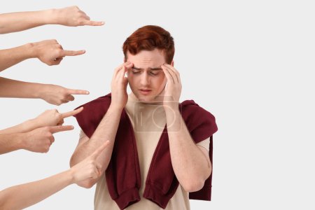 Photo for People pointing at stressed young man on white background. Accusation concept - Royalty Free Image