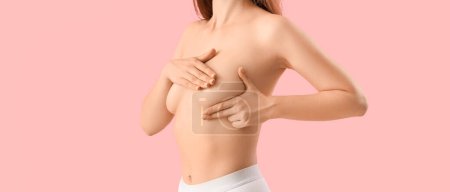 Téléchargez les photos : Jeune femme nue touchant son sein sur fond rose - en image libre de droit