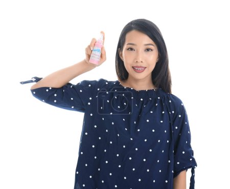 Young Asian woman with mosquito repellent on white background