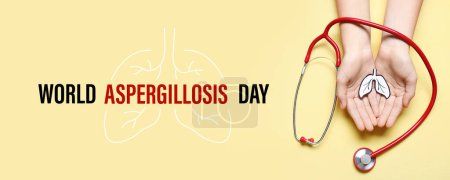 Female hands with paper lungs and stethoscope on yellow background. Banner for World Aspergillosis Day