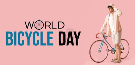 Young man with bicycle on pink background. Banner for World Bicycle Day