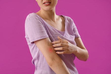 Young woman with mosquito repellent spray on purple background, closeup