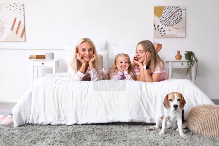 Famille heureuse avec chien mignon dans la chambre
