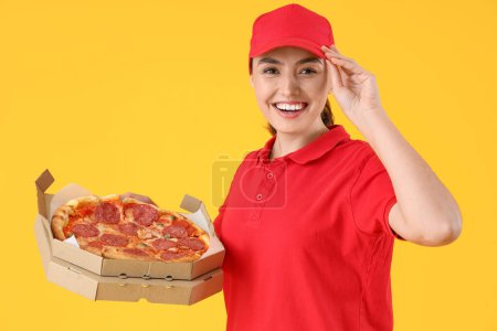 Photo for Female courier with tasty pepperoni pizza on yellow background - Royalty Free Image