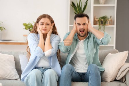 Young couple suffering from loud neighbours at home