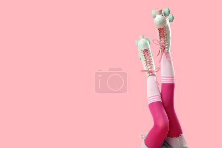 Beine der Frau in Rollschuhen auf rosa Hintergrund