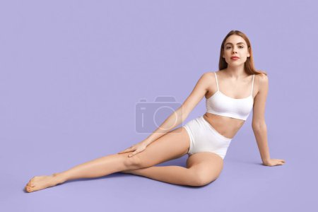 Photo for Beautiful young woman after depilation sitting on purple background - Royalty Free Image