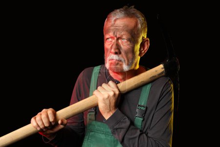 Photo for Mature miner man with pick axe on black background - Royalty Free Image