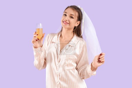 Happy bride in pajamas with glass of champagne on lilac background. Hen Party