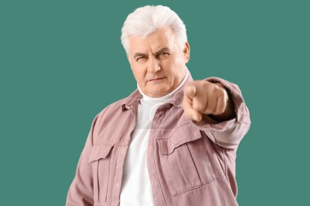 Photo for Mature man pointing at viewer on green background. Accusation concept - Royalty Free Image