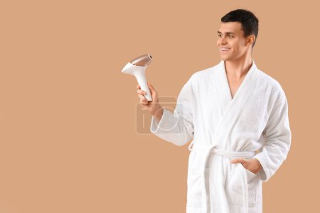 Photo for Young man with photoepilator on beige background - Royalty Free Image