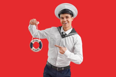 Photo for Young sailor with small ring buoy on red background - Royalty Free Image