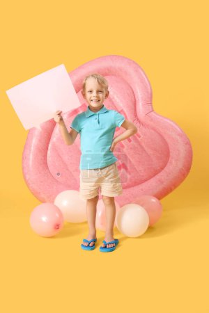 Cute little boy with blank speech bubble, swim mattress and balloons on yellow background