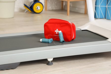Téléchargez les photos : Inhalateurs d'asthme avec trousse de premiers soins sur tapis roulant dans la salle de gym, gros plan - en image libre de droit