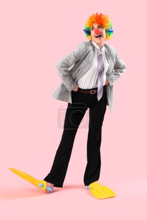 Foto de Joven mujer de negocios en disfraz divertido con aletas sobre fondo rosa - Imagen libre de derechos