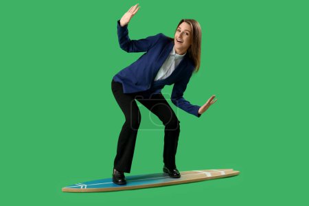 Foto de Joven empresaria divertida con tabla de surf sobre fondo verde - Imagen libre de derechos