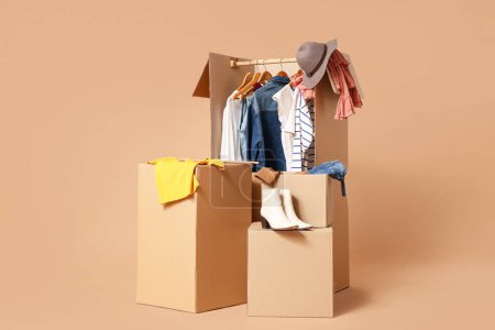 Foto de Cajas de armario con ropa sobre fondo beige - Imagen libre de derechos