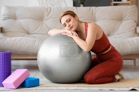 Deportiva mujer madura con fitball experimentar la menopausia en casa