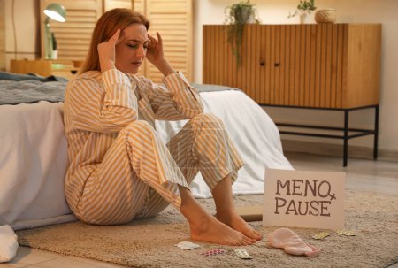 Mujer madura que sufre de migraña en el dormitorio por la noche. Concepto de menopausia
