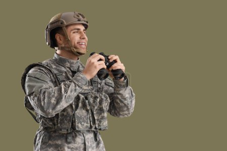 Soldat masculin en uniforme avec jumelles sur fond vert