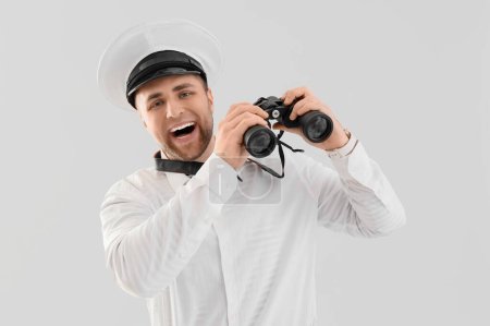 Photo for Young male sailor with binoculars on white background - Royalty Free Image