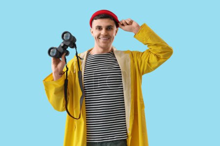 Photo for Young sailor with binoculars on blue background - Royalty Free Image