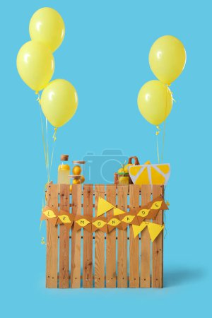 Lemonade stand with balloons on blue background