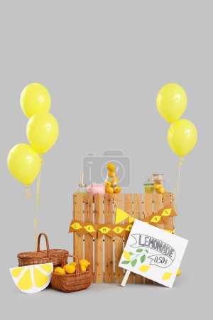 Lemonade stand with balloons on light background
