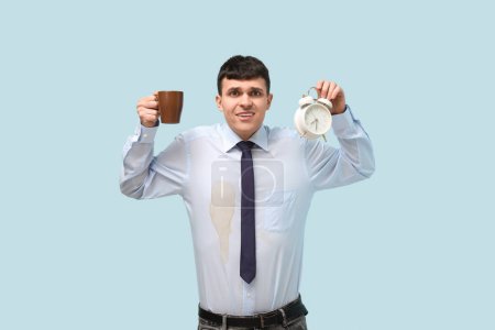 Photo for Confused man with coffee stains on his shirt on blue background - Royalty Free Image