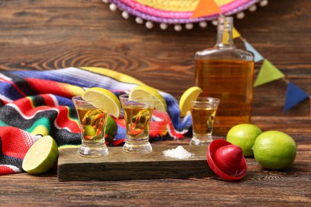 Botella de tequila con tiros y lima sobre fondo de color