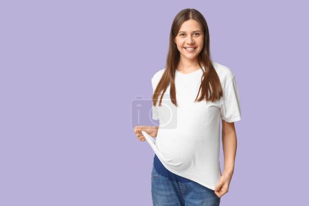 Photo for Beautiful young pregnant woman in stylish white t-shirt on lilac background - Royalty Free Image