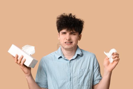 Photo for Young man with tissues on beige background. Allergy concept - Royalty Free Image