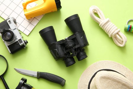 Photo for Binoculars and travel items on green background - Royalty Free Image