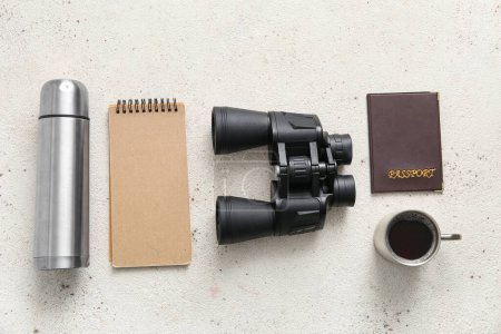 Photo for Travel binoculars, thermos, notebook, passport and cup of coffee on light background - Royalty Free Image