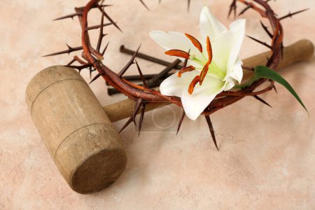 Wooden hammer with crown of thorns, lily and nails on light background