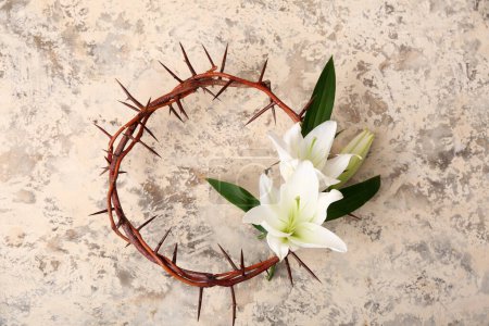 Crown of thorns with white lilies on light grunge background