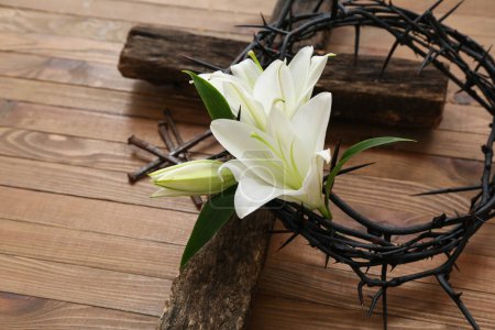 Foto de Corona de espinas con lirios blancos, clavos y cruz sobre fondo de madera - Imagen libre de derechos