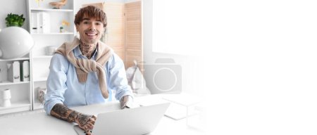 Young tattooed businessman with laptop at workplace in office. Banner for design