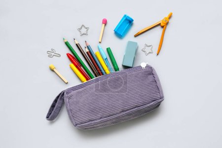 Téléchargez les photos : Étui crayon violet avec papeterie scolaire différente sur fond gris - en image libre de droit