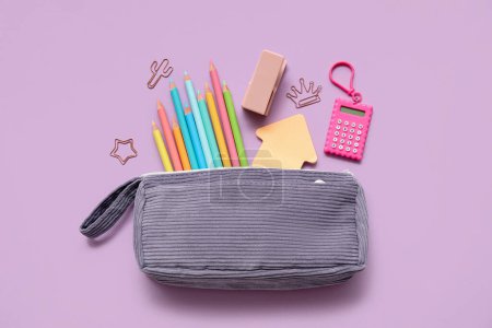 Foto de Caja de lápiz con diferentes artículos de papelería de la escuela sobre fondo púrpura - Imagen libre de derechos